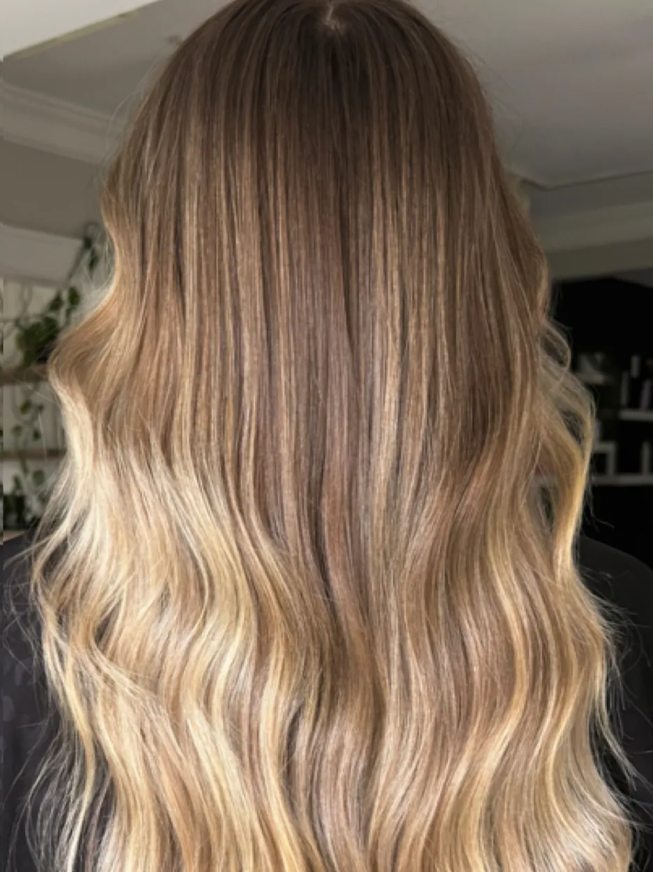 Back view of long blonde balayage with shadow root and beachy waves by hairxlaina